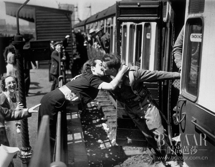 A Woman Leans Over The Railing To Kiss A British Soldier Returning From World War II, London, 1940
